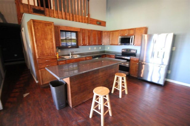 180 Holly Grove Road, Covington, TN 38019 - kitchen featuring dark hardwood / wood-style floors, a breakfast bar, appliances with stainless steel finishes, sink, and a kitchen island