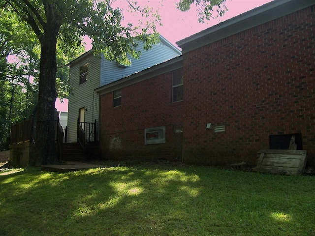 property exterior at dusk with a lawn