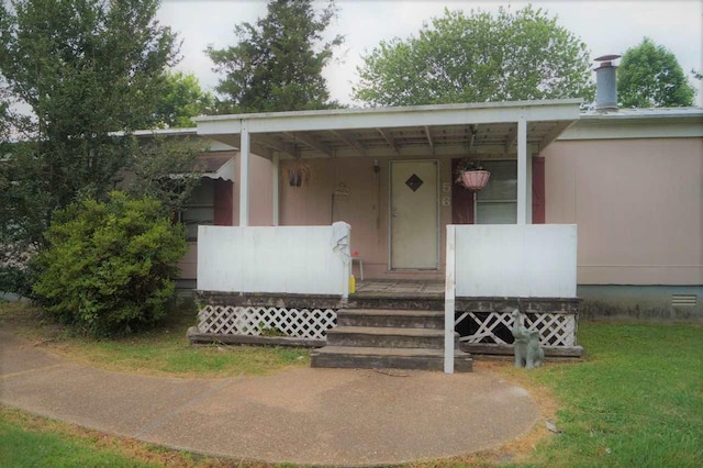 view of exterior entry featuring a yard