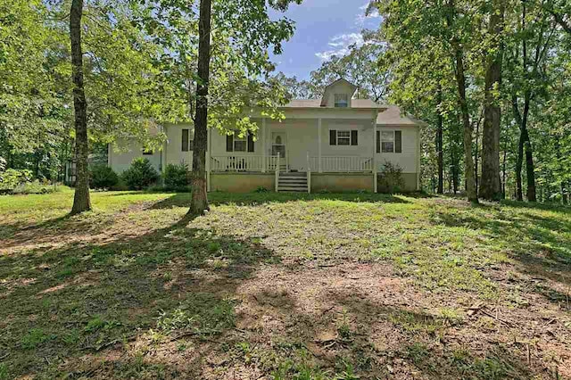 rear view of house featuring covered porch and a yard