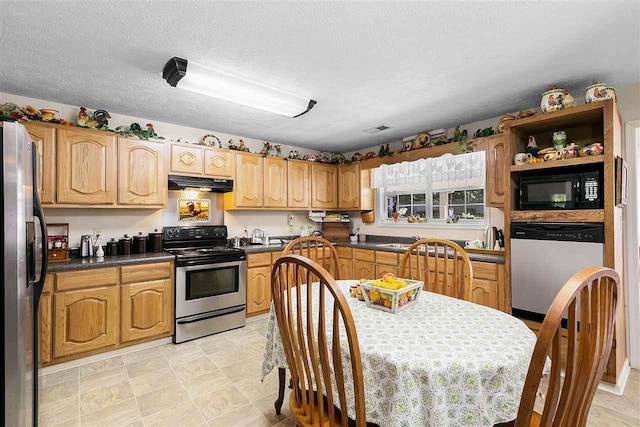 kitchen with a textured ceiling, light tile floors, and appliances with stainless steel finishes