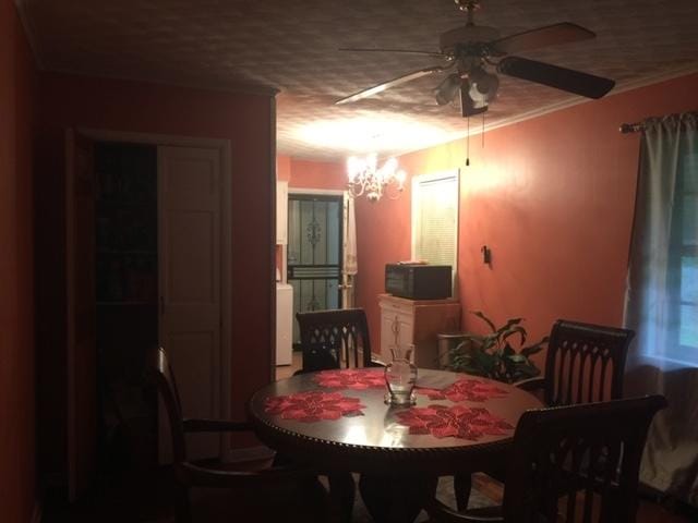 dining space with ceiling fan with notable chandelier