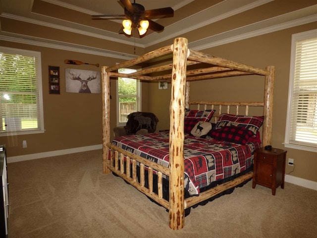 bedroom featuring a raised ceiling, light carpet, ceiling fan, and ornamental molding