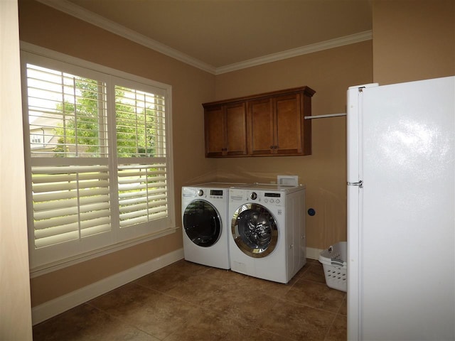 washroom with crown molding, cabinets, washing machine and clothes dryer, and dark tile flooring