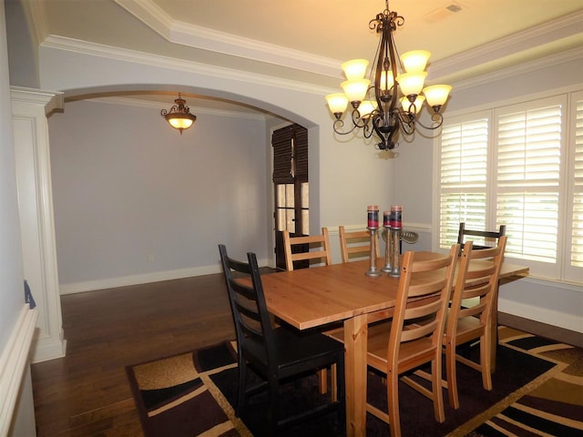 dining room featuring dark hardwood / wood-style flooring, crown molding, a raised ceiling, and a chandelier