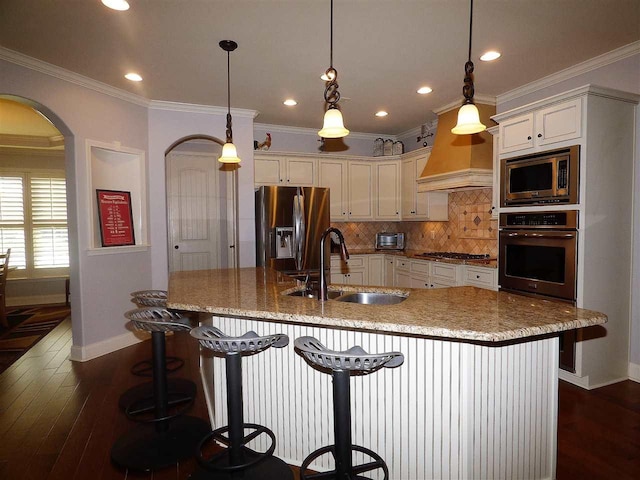 kitchen featuring hanging light fixtures, a breakfast bar, appliances with stainless steel finishes, and sink