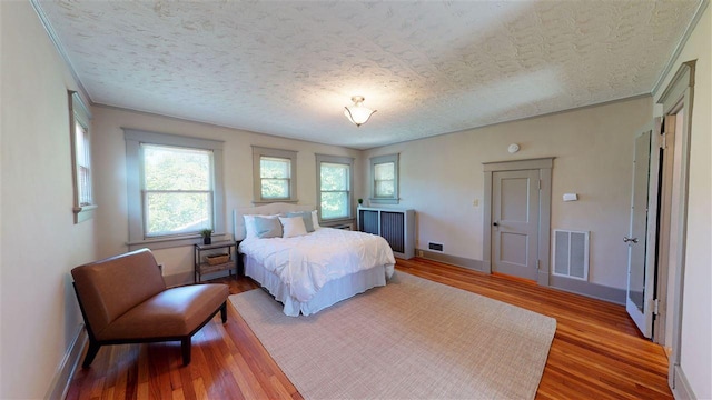 bedroom featuring a textured ceiling and wood-type flooring