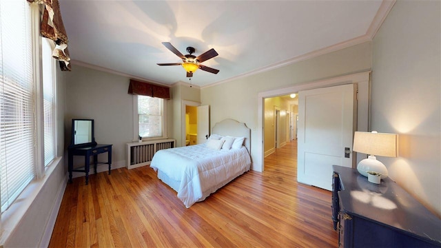 bedroom featuring ceiling fan, ornamental molding, and light wood-type flooring