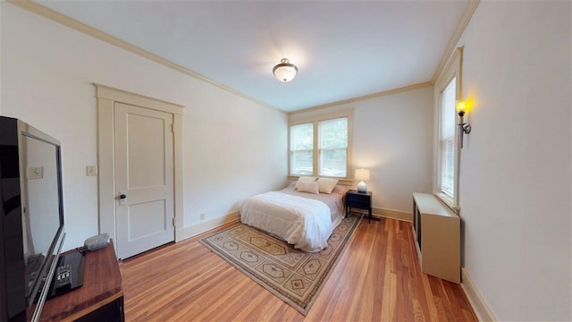 bedroom featuring ornamental molding and light hardwood / wood-style flooring