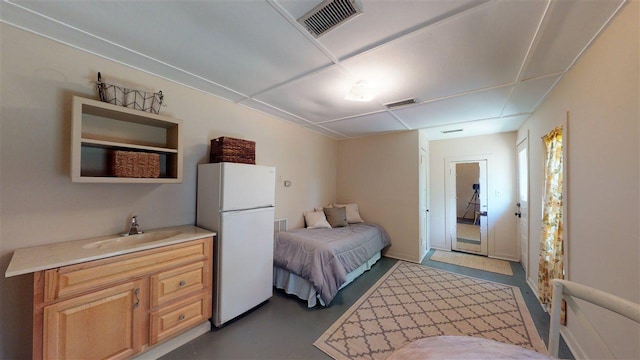 bedroom with white refrigerator and sink