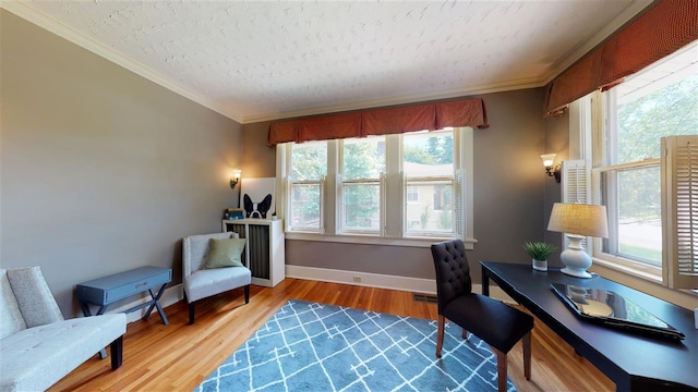 home office with crown molding, a wealth of natural light, and light hardwood / wood-style floors