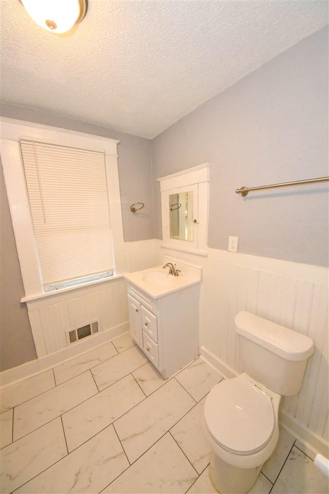 bathroom with vanity, tile flooring, a textured ceiling, and toilet