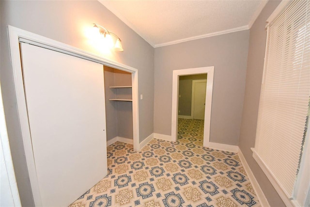 corridor with light tile flooring, a textured ceiling, and crown molding