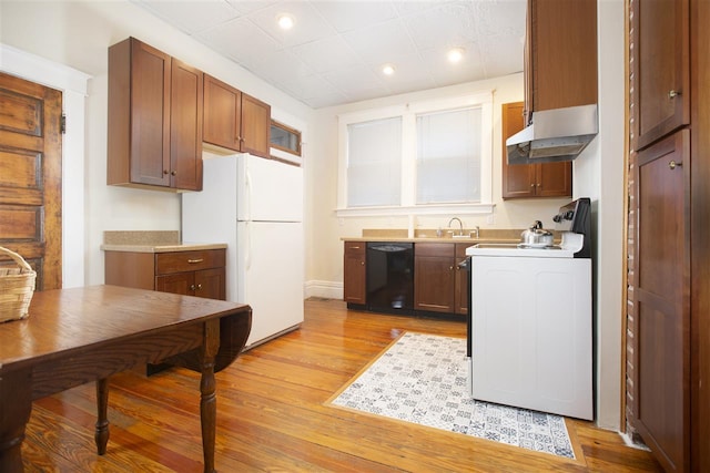 kitchen with light wood-type flooring, dishwasher, sink, white refrigerator, and wall chimney exhaust hood