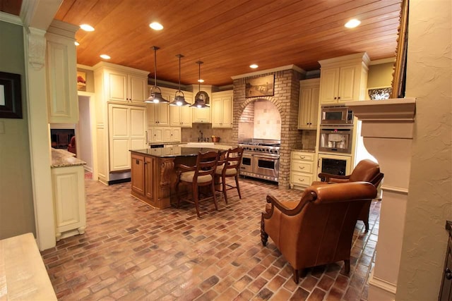 9351 Rocky Valley Cv, Memphis, TN 38018 - kitchen with decorative light fixtures, a kitchen island, a kitchen bar, tasteful backsplash, and appliances with stainless steel finishes