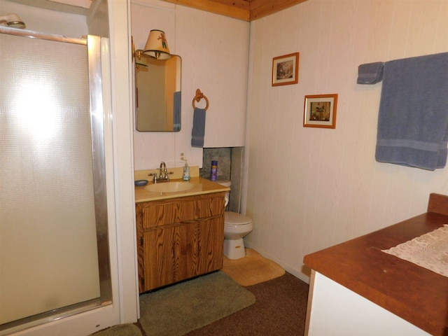 bathroom featuring toilet, vanity, and an enclosed shower