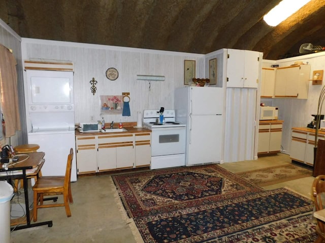 kitchen featuring stacked washer and clothes dryer, white appliances, white cabinets, and sink