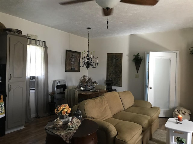 living room with a textured ceiling, dark wood-type flooring, and ceiling fan with notable chandelier