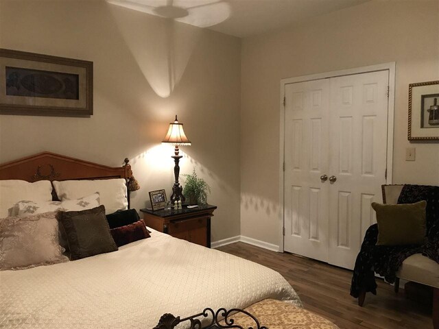 bedroom with a closet, ceiling fan, and dark hardwood / wood-style flooring