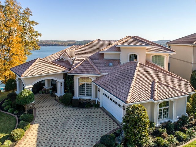 mediterranean / spanish house featuring a water view and a garage