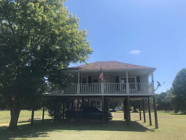 back of house with a carport and a yard