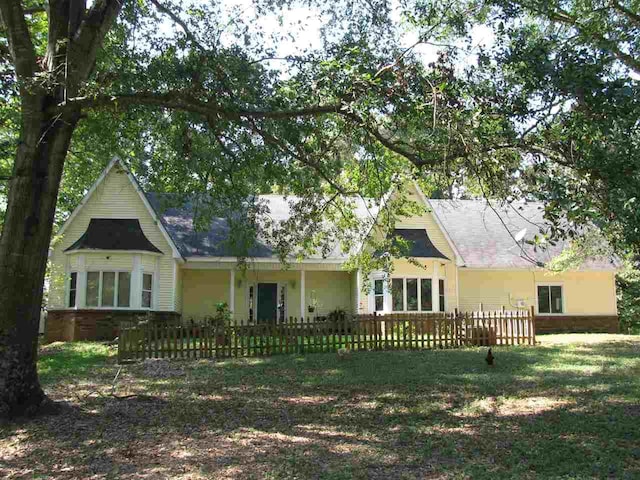 rear view of property featuring a lawn