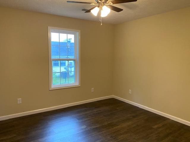 empty room with dark hardwood / wood-style floors and ceiling fan