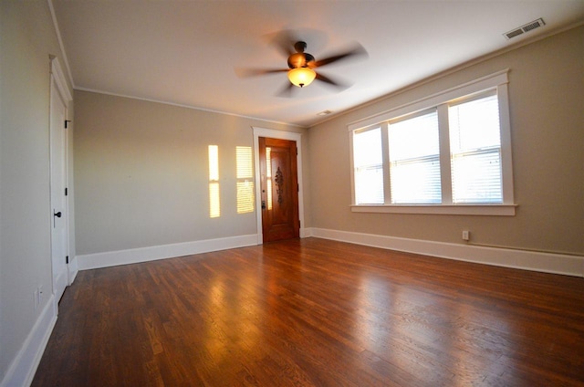 unfurnished room featuring ceiling fan, crown molding, and dark wood-type flooring