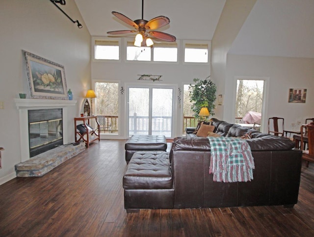 living room with plenty of natural light, high vaulted ceiling, dark hardwood / wood-style floors, and ceiling fan