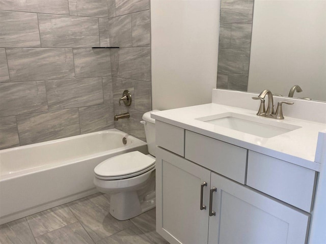 full bathroom featuring tile flooring, tiled shower / bath, toilet, and vanity