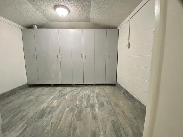 empty room featuring lofted ceiling, a textured ceiling, and hardwood / wood-style floors