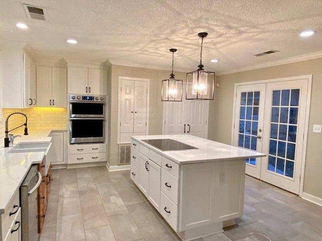 kitchen featuring french doors, sink, a kitchen island, white cabinets, and appliances with stainless steel finishes