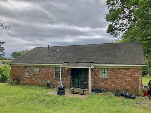 rear view of house with a lawn and a patio