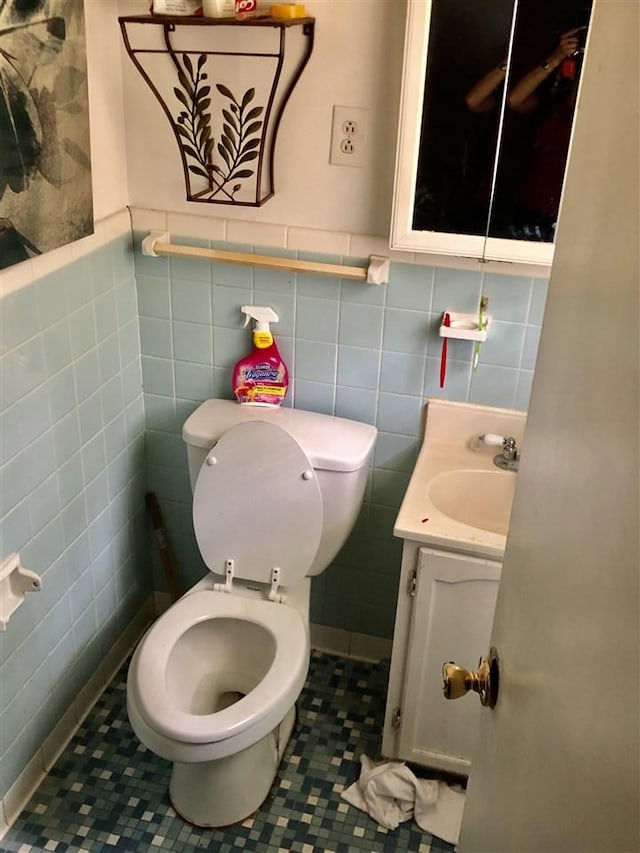 bathroom with vanity, tile flooring, toilet, and tile walls