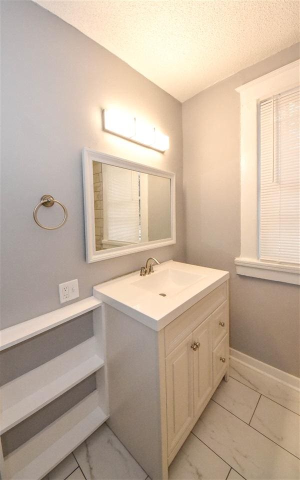 bathroom with tile floors, a textured ceiling, and vanity