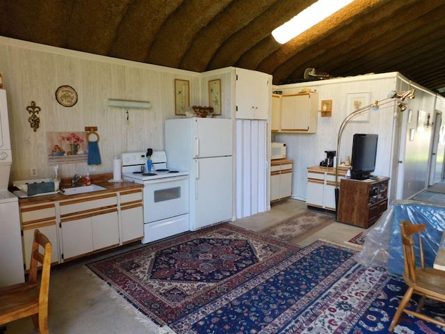 kitchen featuring lofted ceiling, sink, white appliances, and white cabinetry