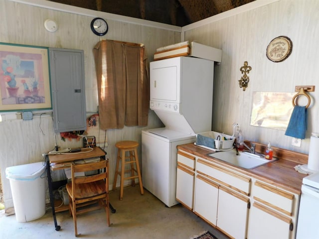 kitchen featuring white cabinetry, stacked washing maching and dryer, and sink