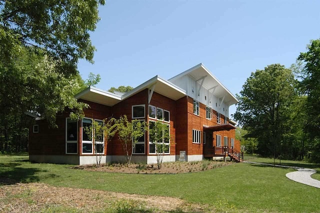 rear view of house featuring a lawn