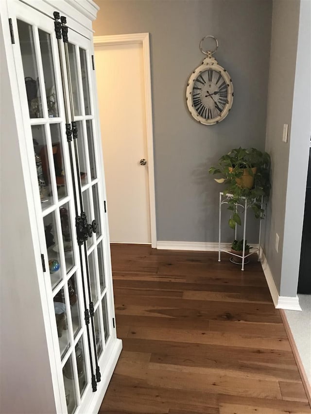 hallway with dark hardwood / wood-style flooring and french doors