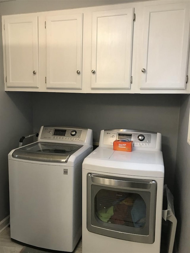 laundry area with washing machine and dryer and cabinets