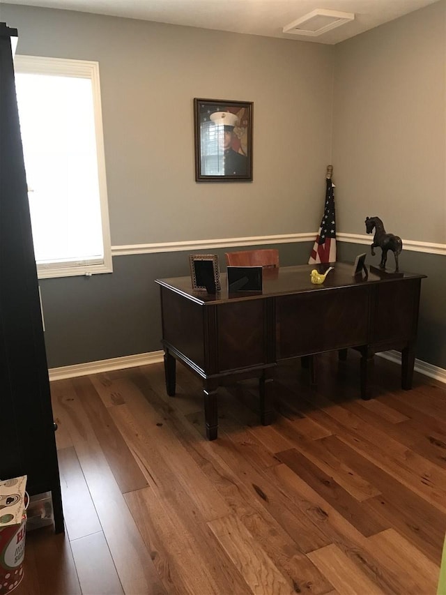 office featuring dark wood-type flooring and a healthy amount of sunlight