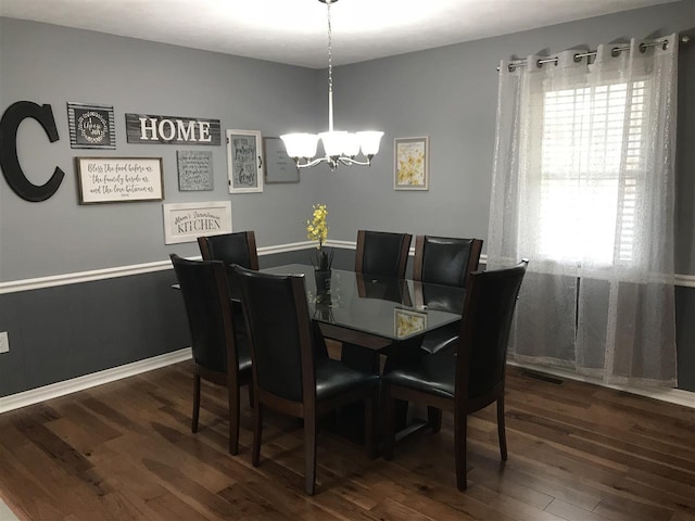 dining space with a chandelier and dark hardwood / wood-style floors