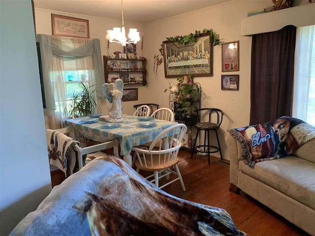 dining area featuring crown molding, dark hardwood / wood-style flooring, and a chandelier