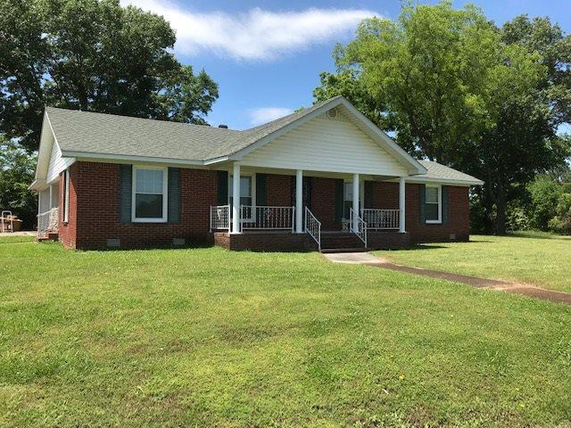 view of front of house featuring covered porch and a front lawn