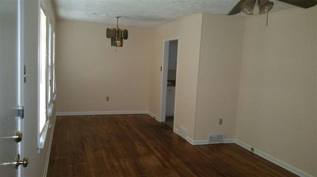 empty room with a textured ceiling, dark hardwood / wood-style floors, and ceiling fan with notable chandelier