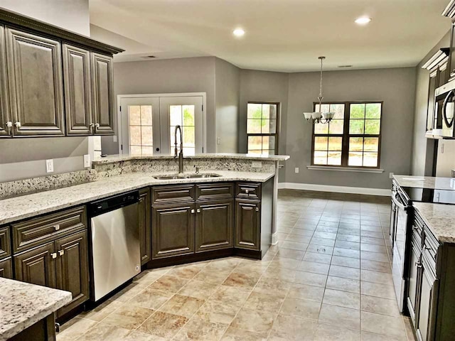 kitchen featuring a healthy amount of sunlight, appliances with stainless steel finishes, light tile floors, and sink