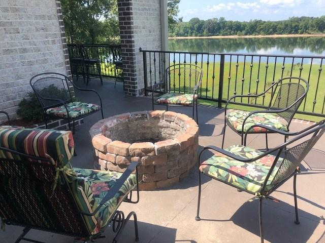 view of terrace with a water view and an outdoor fire pit