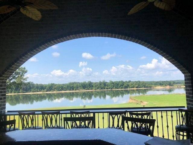 balcony with ceiling fan and a water view