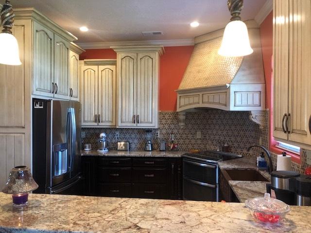 kitchen with electric stove, black refrigerator with ice dispenser, sink, backsplash, and light stone countertops