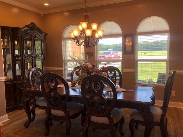 dining room featuring an inviting chandelier, crown molding, and dark hardwood / wood-style flooring